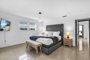 a bedroom with a bed and a table and a window at Miami Paradise Waterfront Games in North Miami Beach