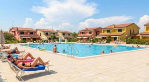 a group of people laying on chairs in a swimming pool at Villaggio dei Fiori in Caorle