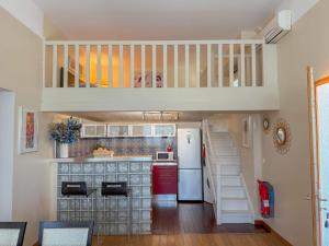 a small kitchen with a loft with a staircase at Gite Mireille in Carros