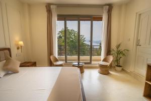 a bedroom with a bed and a large window at Barylia in Mawlyngkhung