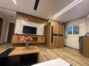 a living room with a television and a vase of flowers at New City Plaza in Cairo