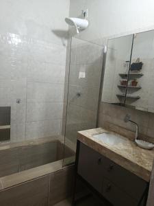 a bathroom with a shower and a sink and a mirror at Espaço Bahia Bella in Porto Seguro