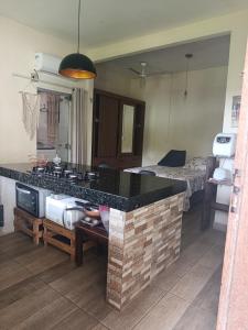 a kitchen with a counter and a room with a bed at Espaço Bahia Bella in Porto Seguro