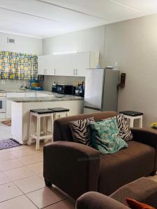 a living room with a couch and a kitchen at Apt 66 Eden Wilds Umtamvuna Getaway in Port Edward