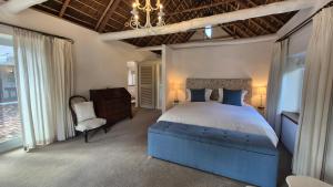a bedroom with a blue bed and a chair at Coppull Private Nature Reserve in Stanford