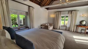 a bedroom with a large white bed and windows at Coppull Private Nature Reserve in Stanford