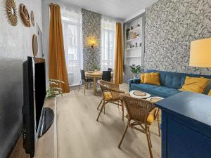 a living room with a blue couch and a table at Superbe appartement au centre de POISSY in Poissy