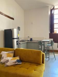 a living room with a yellow couch and a kitchen at Apartamento VIP en Buga in Buga