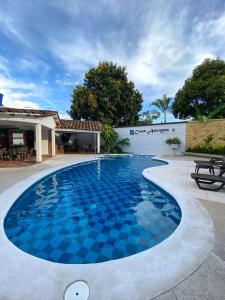 a swimming pool with blue tiles in front of a building at Apartamento VIP en Buga in Buga