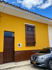 a yellow house with a car parked in front of it at Apartamento VIP en Buga in Buga