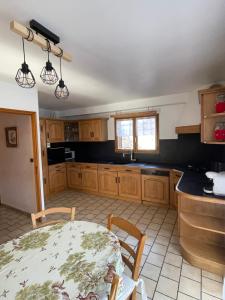 a kitchen with wooden cabinets and a table with chairs at Chalet les Lurins in Villarlurin