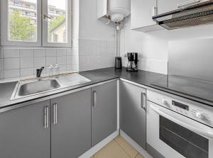 a kitchen with a sink and a counter top at Superbe appartement au centre de POISSY in Poissy +13 photos