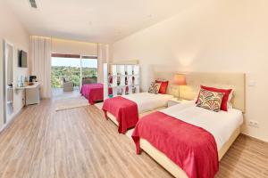 a bedroom with two beds and a balcony at Hotel Rural Quinta do Marco - Nature & Dining in Tavira +47 photos