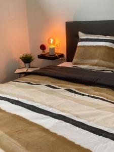 a bed with a black and white comforter in a bedroom at Tiny House Ô Secret du Wérihay in Spa