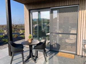 a patio with a table and chairs on a balcony at Tiny House Ô Secret du Wérihay in Spa
