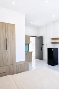a kitchen with wooden cabinets and a black refrigerator at The One Apartments in Tân Uyên
