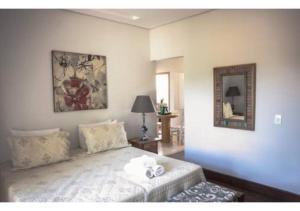 a bedroom with a bed and a mirror at Lofts do Largo in Tiradentes