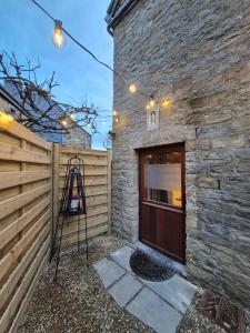 a building with a wooden door and a fence at Le pas de la Fagne in Sprimont