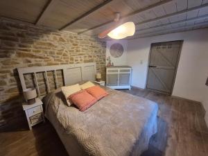 a bedroom with a large bed and a stone wall at Le pas de la Fagne in Sprimont
