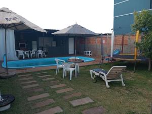 a patio with a table and chairs next to a pool at QUARTO CONTEINER, EDICULA ABERTA E PISCINA AQUAVibes in Cascavel +5 photos