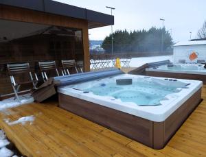 a jacuzzi tub on a deck with a table at Szépia Bio and Art Hotel in Zsámbék