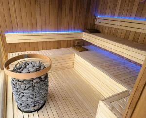 a sauna with a bucket of rocks in it at Szépia Bio and Art Hotel in Zsámbék