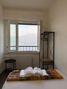 a bed in a room with a large window at Lake Como Hostel in Menaggio