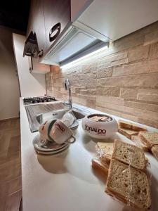 a kitchen counter with bread and bowls of food on it at Casetta n'da civita in Castrovillari +2 photos
