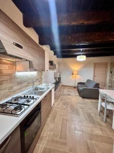 a kitchen with a stove top oven next to a couch at Casetta n'da civita in Castrovillari