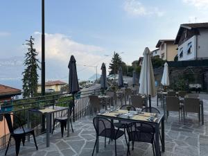 a row of tables and chairs with umbrellas on a patio at Lake Como Hostel in Menaggio