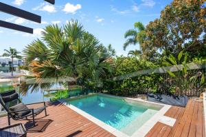 a swimming pool on top of a wooden deck with a patio at Wanderlust heated pool rooftop deck in Gold Coast