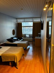 a hotel room with two beds and a window at Hotelli Pihkuri in Viitasaari