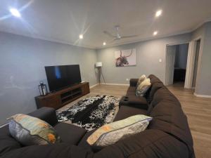 a living room with a couch and a flat screen tv at Nguni Rest in Barberton