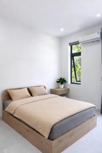 a bedroom with a large bed in a white room at The One Apartments in Tân Uyên +20 photos