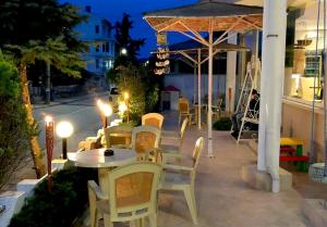 a table and chairs on a patio at night at Hotel Andre in Burgas