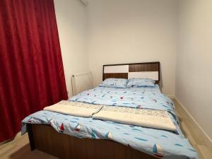 a bedroom with a bed with a red curtain at Cozzy Apartment in Prishtinë +4 photos
