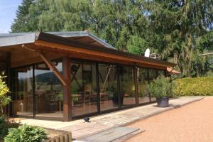a gazebo with glass windows and a roof at Chalet du Cerf dans un cadre de verdure in Gerbépal