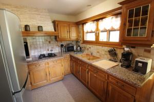 a kitchen with wooden cabinets and a refrigerator at Chalet du Cerf dans un cadre de verdure in Gerbépal