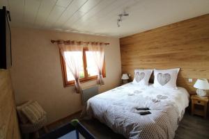 a bedroom with a white bed with a window at Chalet du Cerf dans un cadre de verdure in Gerbépal