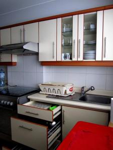 cocina con armarios blancos, fregadero y fogones en Kennedy Park 601 Apartment en Lima