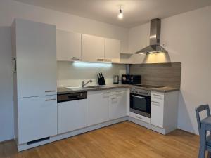 a kitchen with white cabinets and a sink and a stove at QuietApt Vienna in Vienna