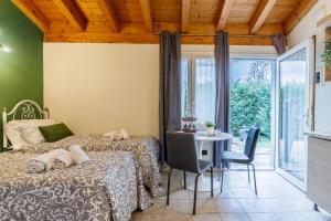 a bedroom with two beds and a table and a window at Le Dimore Apartments - Garden & Private Parking in Verona