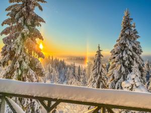 a winter sunrise in the mountains with snow covered trees at Holiday Home Joutsen a by Interhome in Ruka