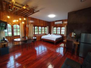 a bedroom with a bed and a desk and a table at บ้านพักมิตรภาพโฮมสเตย์ in Ban Choko