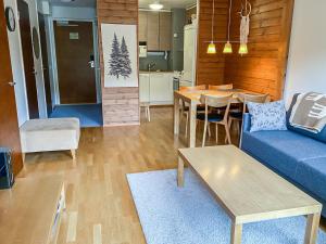 a living room with a blue couch and a table at Holiday Home Ylläs chalets a307 by Interhome in Ylläs