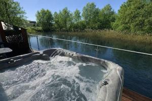 a bath tub sitting on the side of a river at Harrier Lodge in Cirencester
