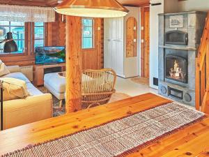 a living room with a couch and a fireplace at Holiday Home Eskola by Interhome in Lahdenperä