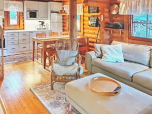 a living room with a couch and a table at Holiday Home Eskola by Interhome in Lahdenperä