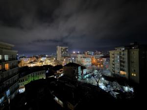 a view of a city at night at Cozzy Apartment in Prishtinë