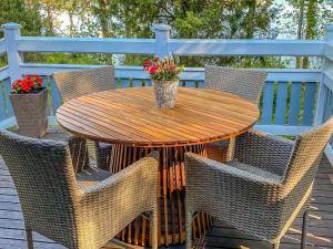 a wooden table and chairs on a deck at Holiday Home Sointukallio by Interhome in Savonlinna